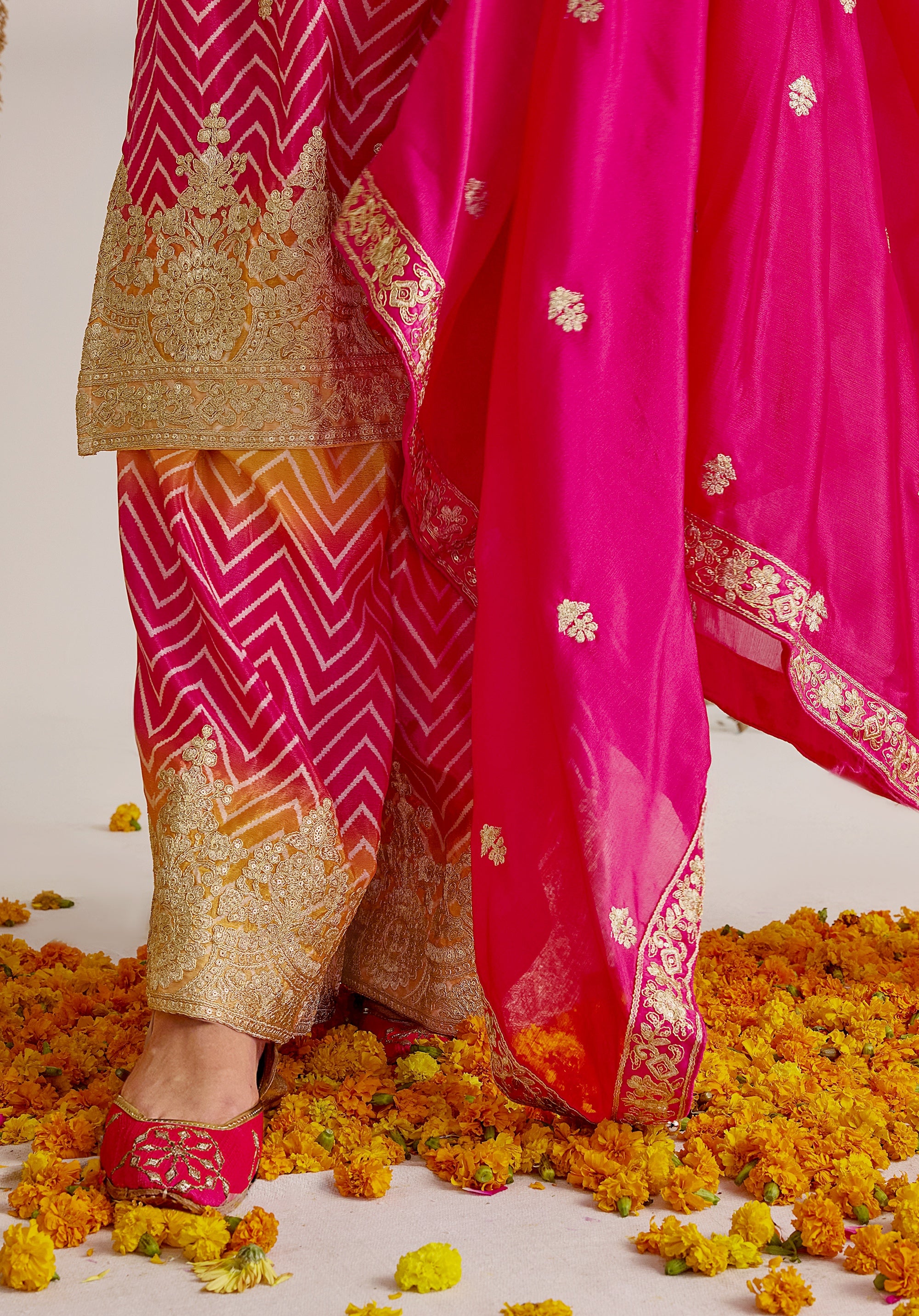 Gradient yellow pink Ira suit Indian ethnic wear: premium chiffon silk with gold floral embroidery, leheriya palazzo gold borders, ethereal tassel dupatta, buy salwar kameez online for festive grace.