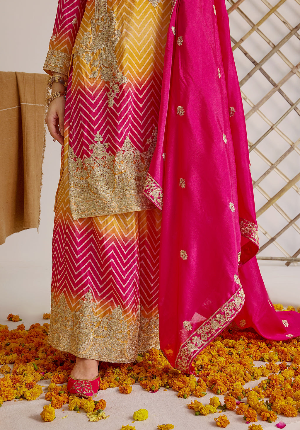 Gradient yellow pink Ira suit Indian ethnic wear: premium chiffon silk with gold floral embroidery, leheriya palazzo gold borders, ethereal tassel dupatta, buy salwar kameez online for festive grace.