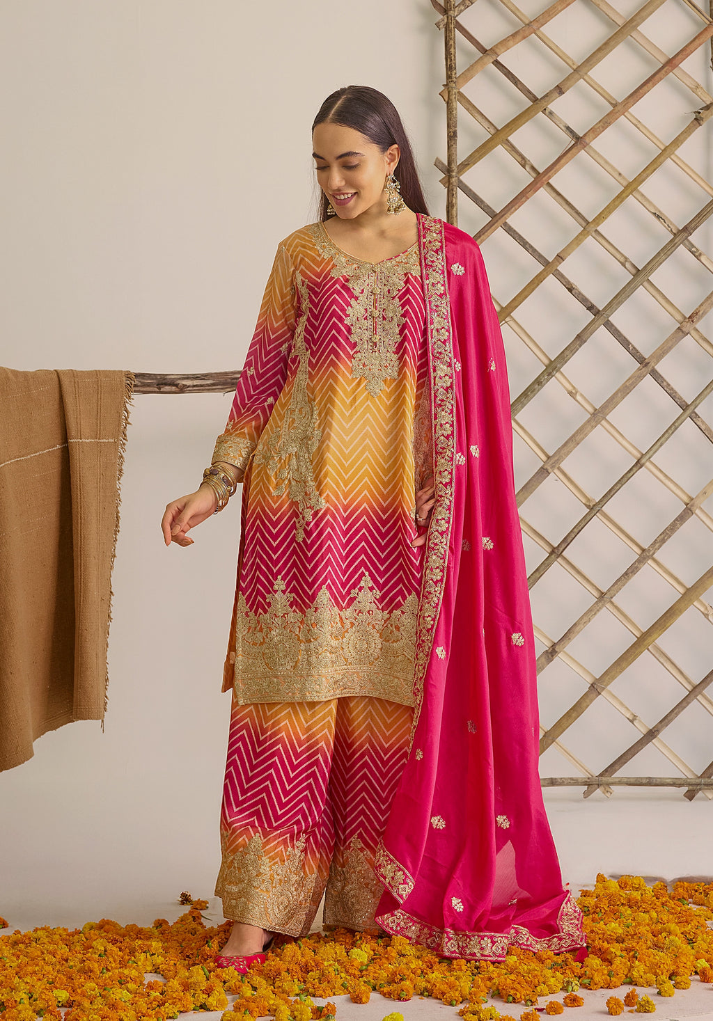 Gradient yellow pink Ira suit Indian ethnic wear: premium chiffon silk with gold floral embroidery, leheriya palazzo gold borders, ethereal tassel dupatta, buy salwar kameez online for festive grace.