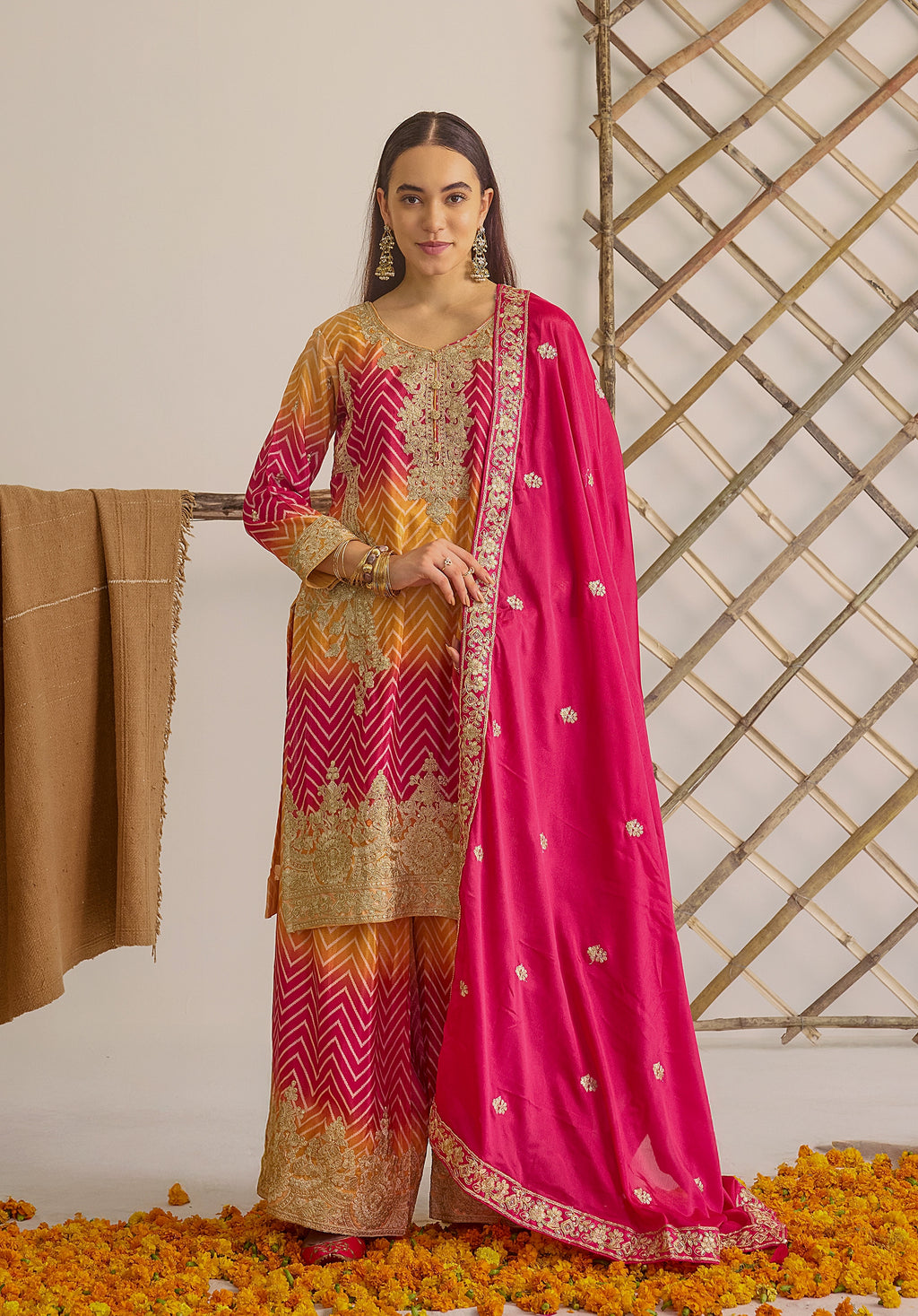 Gradient yellow pink Ira suit Indian ethnic wear: premium chiffon silk with gold floral embroidery, leheriya palazzo gold borders, ethereal tassel dupatta, buy salwar kameez online for festive grace.
