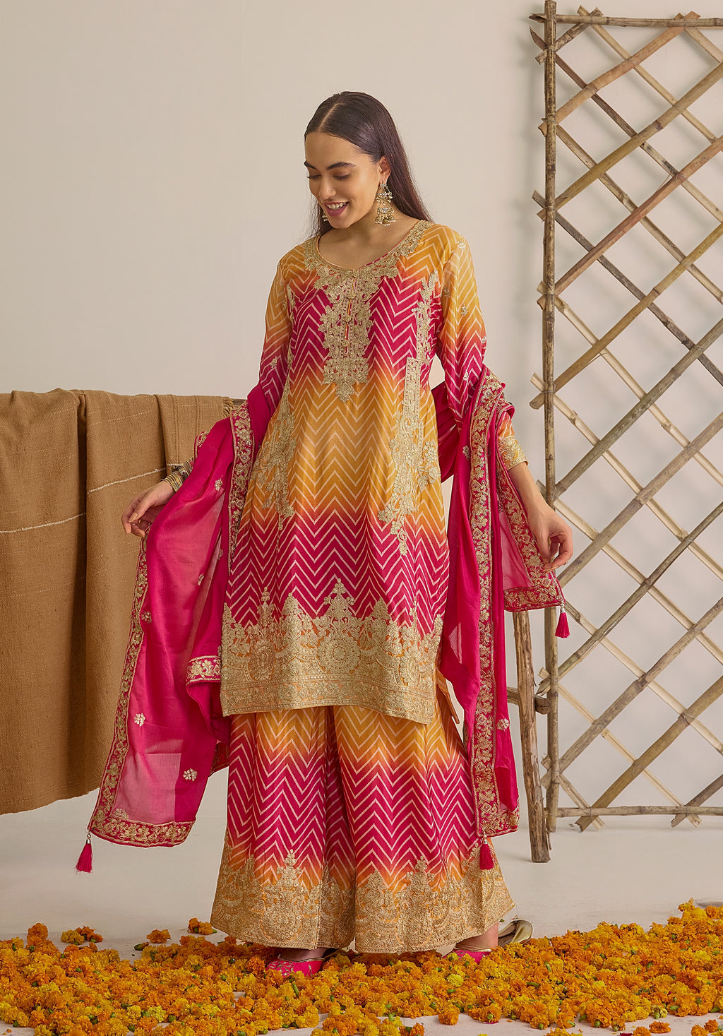 Gradient yellow pink Ira suit Indian ethnic wear: premium chiffon silk with gold floral embroidery, leheriya palazzo gold borders, ethereal tassel dupatta, buy salwar kameez online for festive grace.