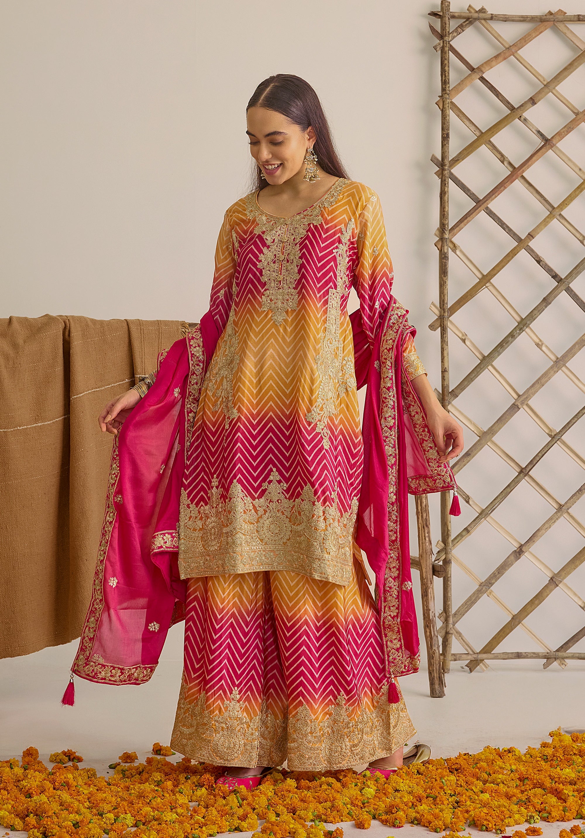 Gradient yellow pink Ira suit Indian ethnic wear: premium chiffon silk with gold floral embroidery, leheriya palazzo gold borders, ethereal tassel dupatta, buy salwar kameez online for festive grace.