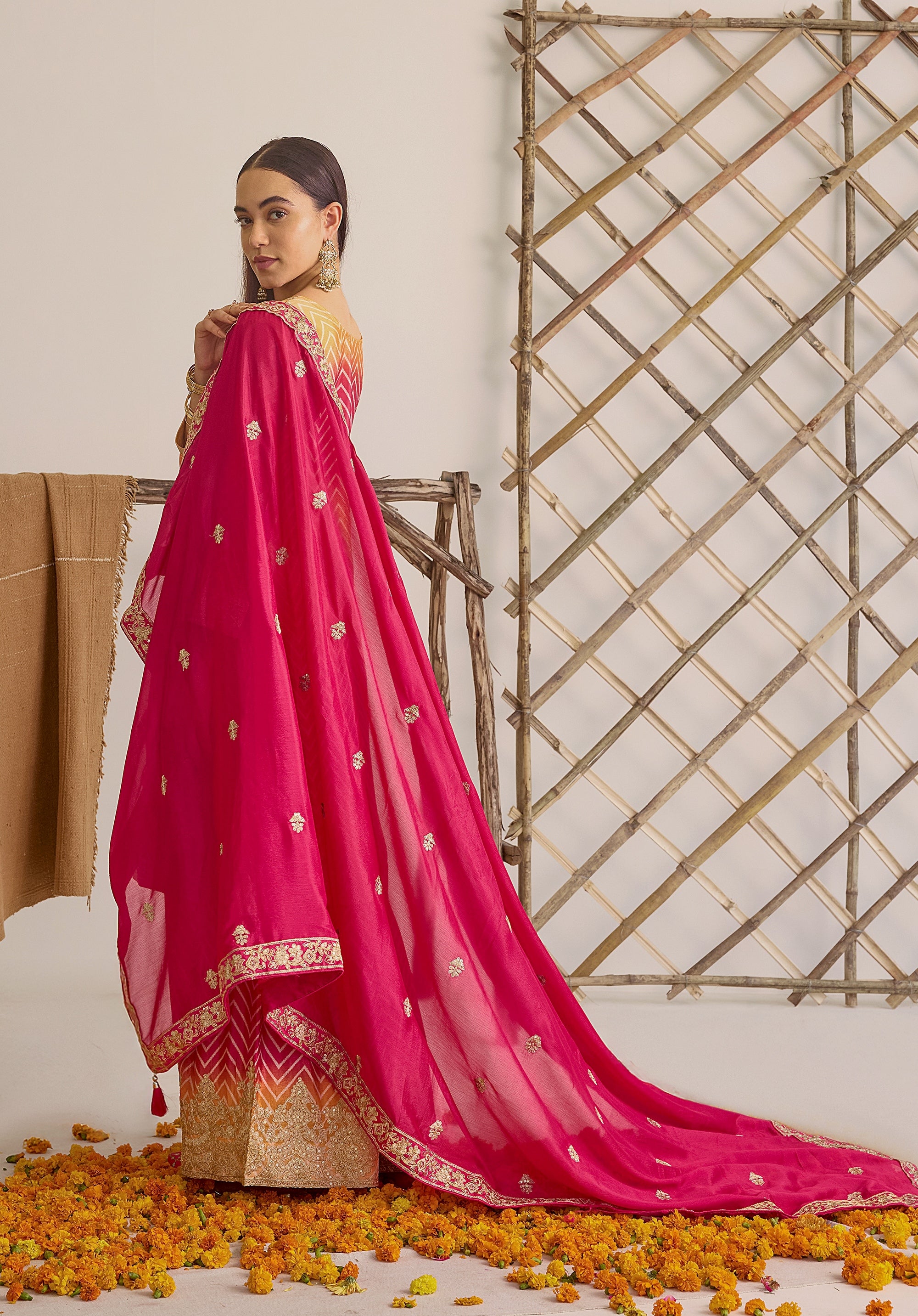 Gradient yellow pink Ira suit Indian ethnic wear: premium chiffon silk with gold floral embroidery, leheriya palazzo gold borders, ethereal tassel dupatta, buy salwar kameez online for festive grace.